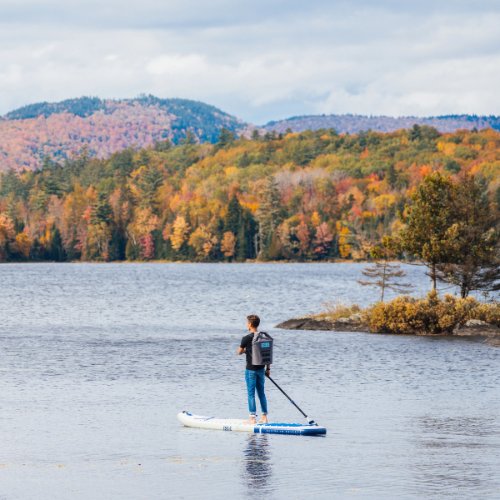 Isle paddler on an autumn lake, powered by Air Core Composite rigidity
